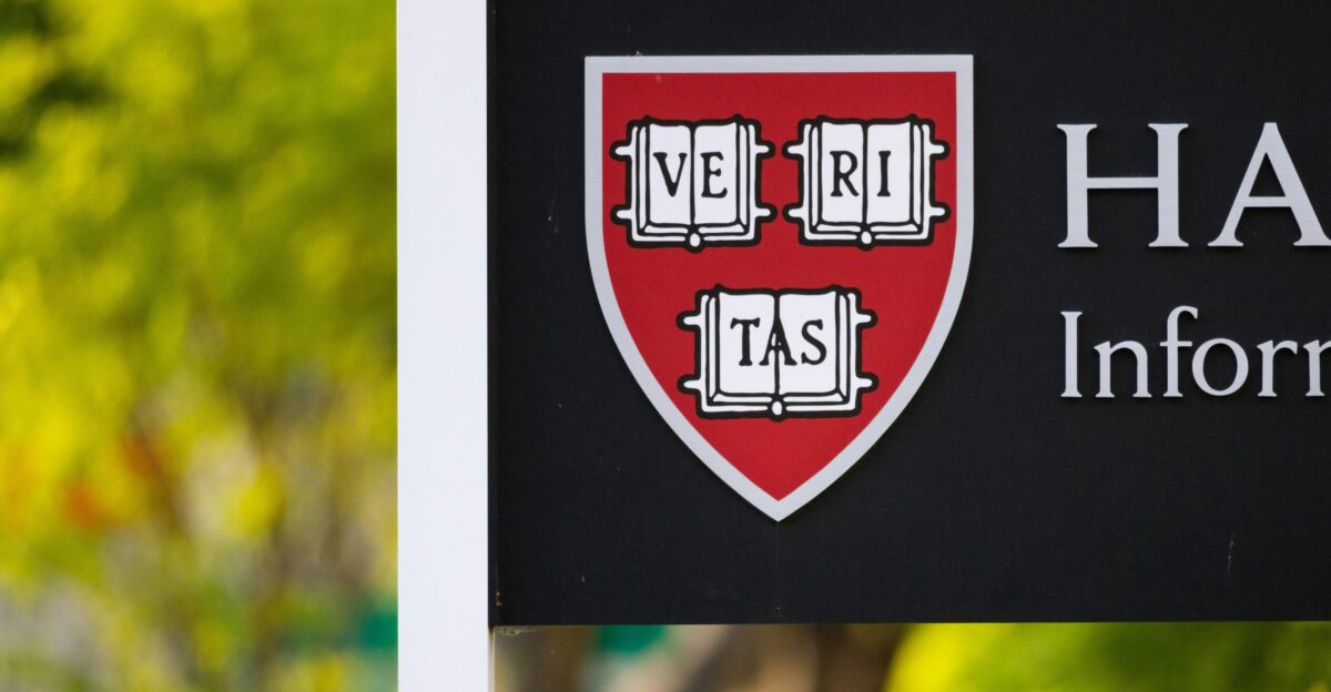 a black and white sign with a red shield on it