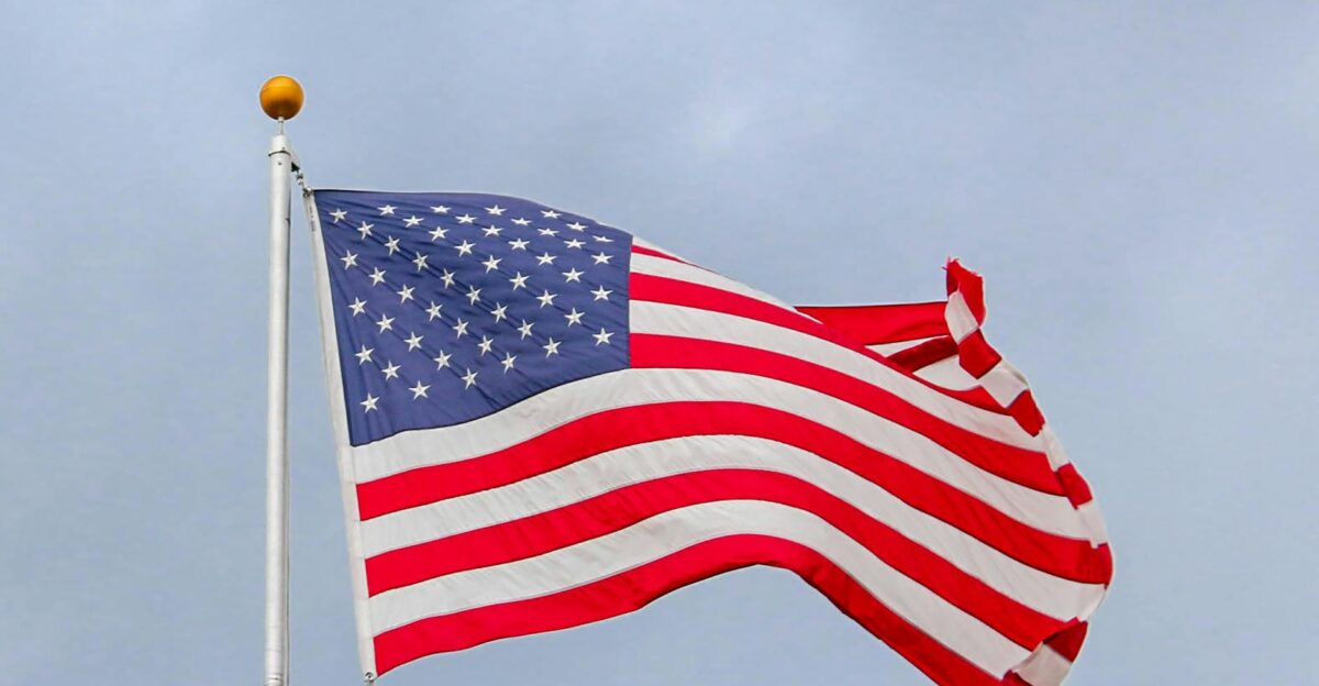 A vibrant image of the American flag waving proudly against a clear blue sky symbolizing freedom