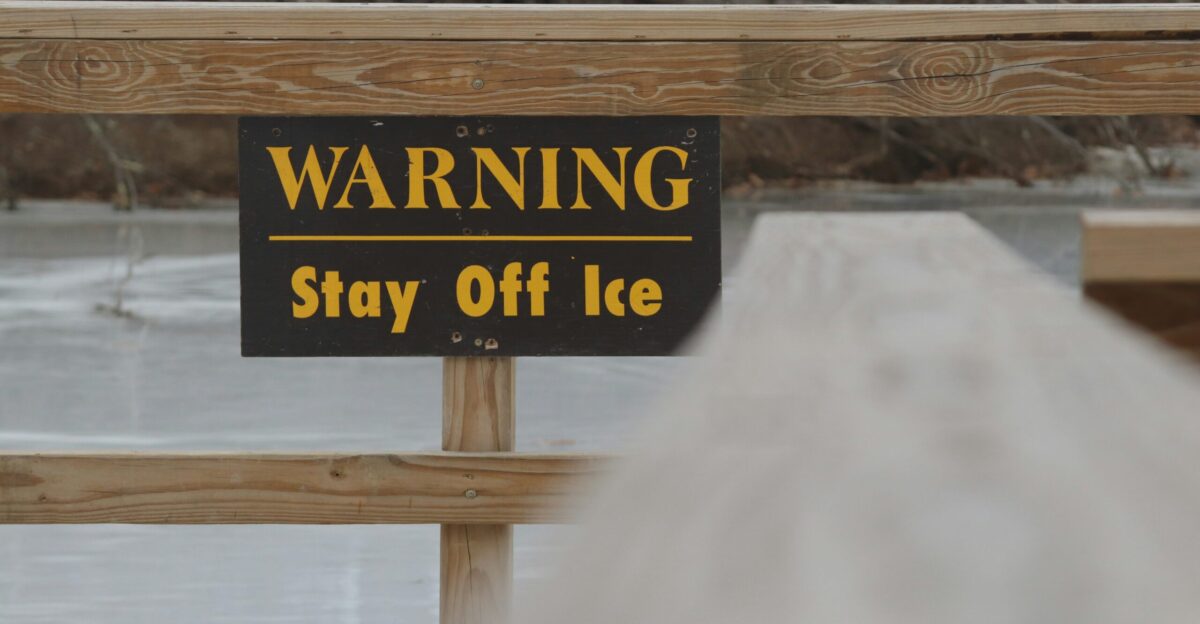 a sign warning of stay off ice on a bridge