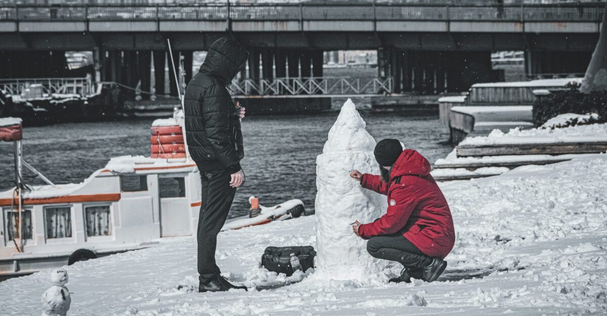 a man and a woman building a snowman