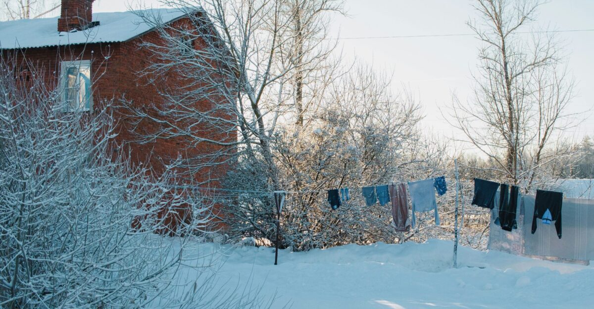 a red house with clothes hanging out to dry in the snow