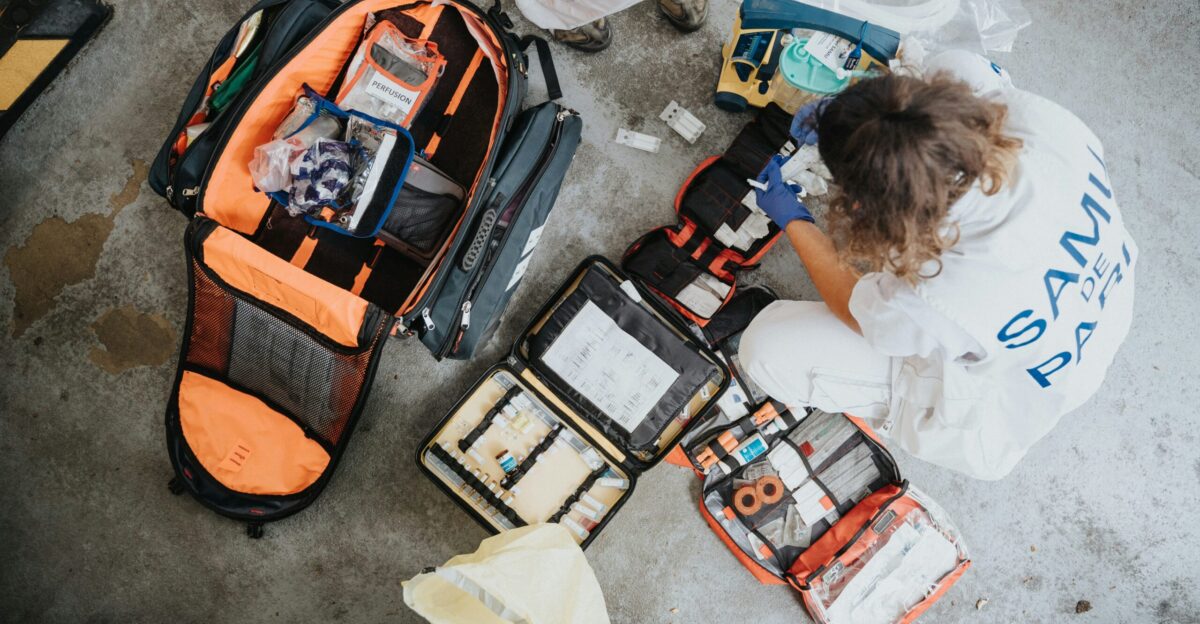 boy in white shirt sitting on orange and black backpack