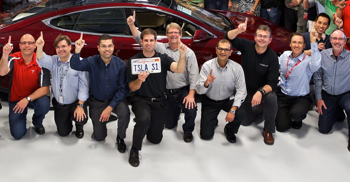Approximate crop of mostly Tesla executives from front row to ease of further cropping Could be extended right leftwards to include additional people when names and faces are matched up Licence plate TSLA S1 Tesla Model S VIN 1 Tesla HQ Salute With one finger up for the first Model S delivery VIN 0001 at the Deer Park HQ Driving inside is OK for an EV