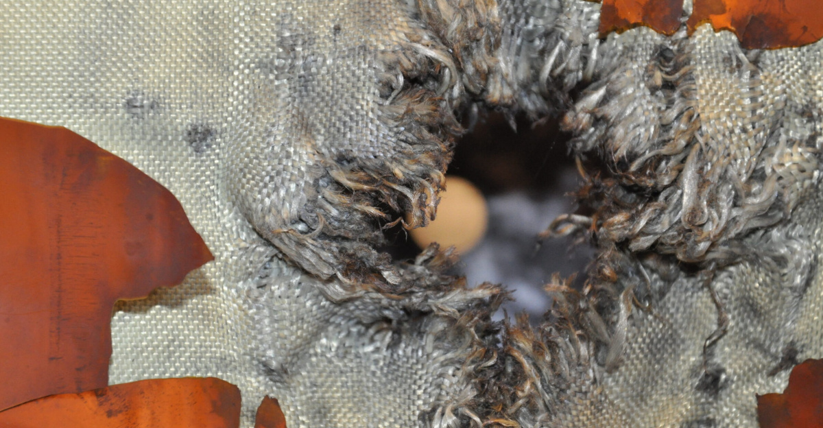 An exit hole through Kevlar–Nextel fabric after hypervelocity testing of the multilayer shielding for ESA’s ATV space freighter, simulating an impact by space debris. The good news is that testing confirms the spacecraft's pressure shell would survive such a collision intact.
<p>Testing was carried out for ESA’s Space Environment and Effects section at the Fraunhofer Institute for High-Speed Dynamics, Ernst-Mach-Institut, EMI, in Freiburg, Germany, using a high-performance light-gas gun.
A 7.5 mm-diameter aluminium bullet was shot at 7 km/s towards the same ‘stuffed Whipple shield’ design used to protect the ATV and the other International Space Station manned modules.
This represents the upper end of the size of debris the shield is designed to cope with. Multiple layers give greater protection than a single thick aluminium layer.
The debris begins by piercing ablanket of multilayer insulation, followed by a 1 mm-thick aluminium ‘bumper shield’.
This impact makes the solid object break apart into a cloud of fragments and vapour, which becomes easier for the following layers to capture or deflect. Next comes the layer of stuffing seen in this main photo, a weave of lightweight Kevlar and Nextel fabric, which further slows the incoming debris.
The stuffing fabric and a surrounding sheet has been thoroughly shredded by the impact, but the overall mass and energy of the debris has been sufficiently dissipated that it has merely harmlessly scorched the innermost 3-mm-thick aluminium wall.
In orbit, this entire shield measures just 128 mm across.
The stronger-than-steel Kevlar fabric was invented by Stephanie Kwolek of the DuPont company, who died this month.
On Earth, her invention’s ‘killer app’ proved to be bulletproof vests; its use on the Space Station helps to ensure that module hulls could be designed several centimetres thinner than would otherwise be the case.
</p>
ESA’s next and finalATV,Georges Lemaître, will be launched to the orbital outpost this summer.