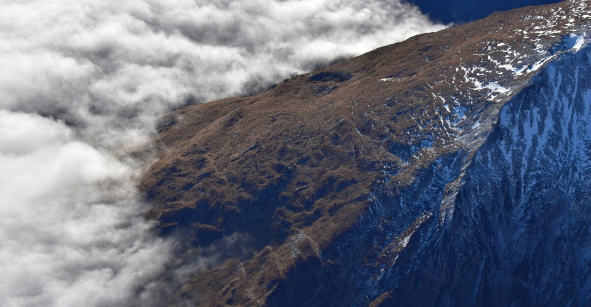 brown and green mountain under white clouds and blue sky during daytime